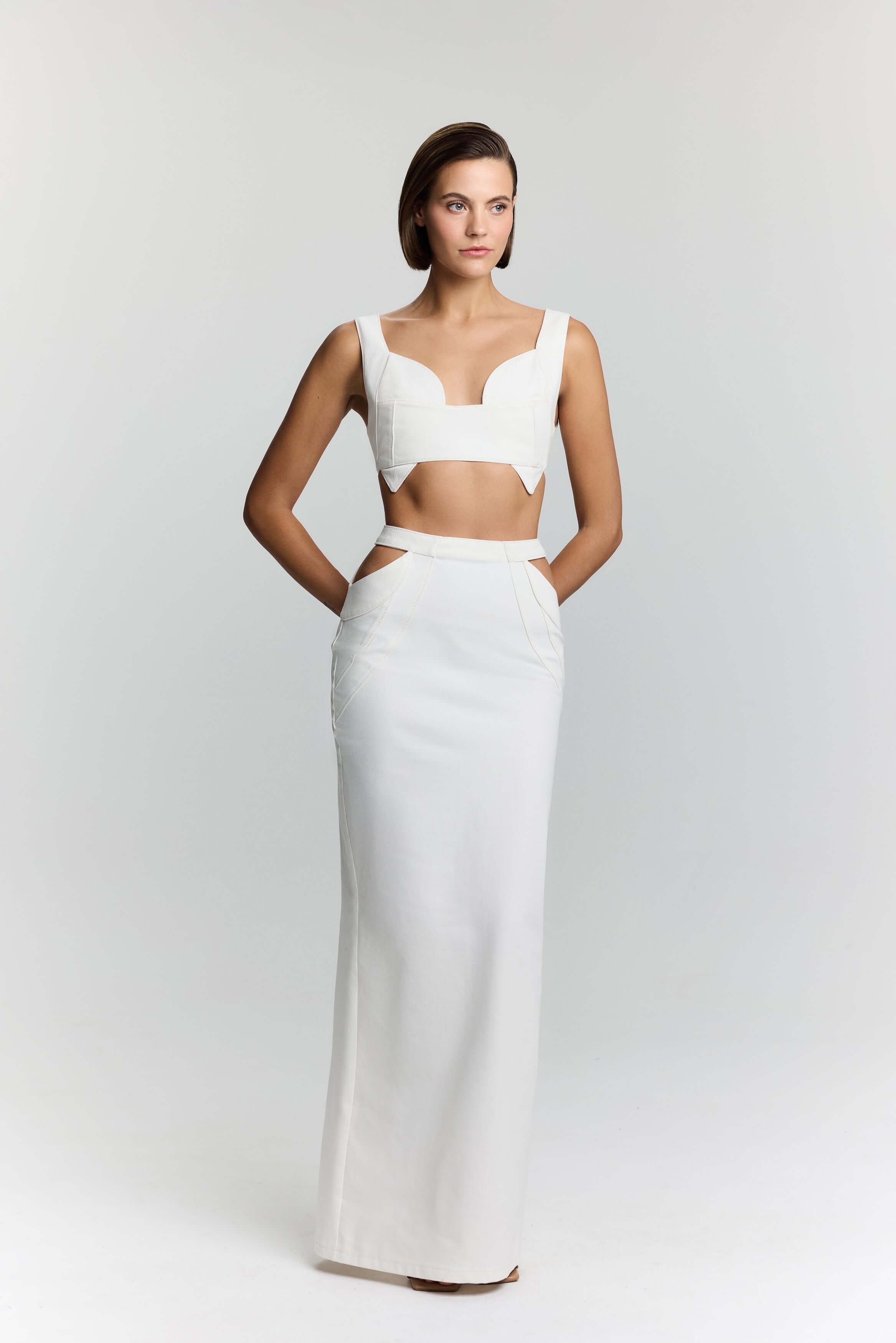 JENDUE's "Elena" white maxi skirt, perfect for a sophisticated look with subtle hip detail.