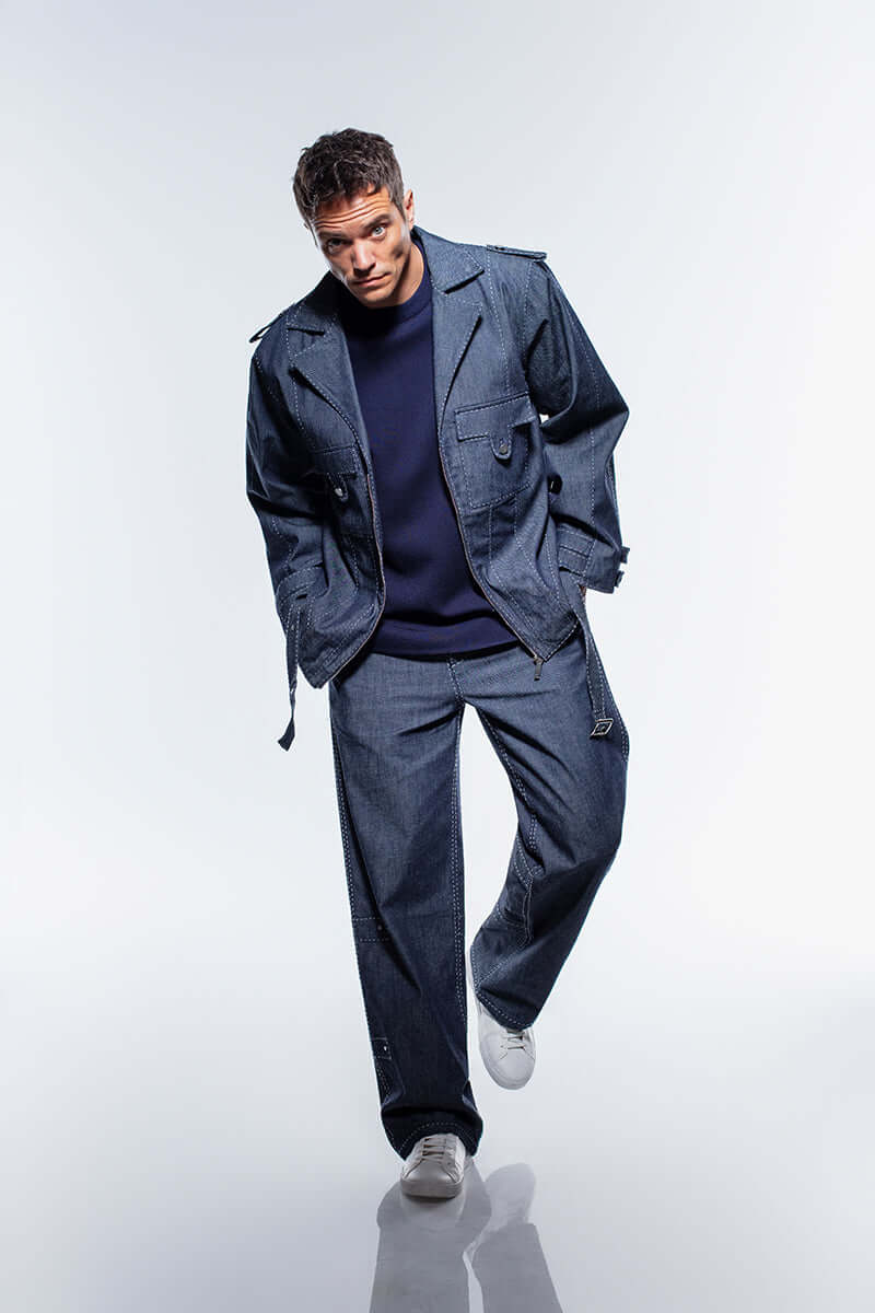 The JENDUE Fortidude denim jacket in navy blue, with two button-flap pockets on the chest and a distinctive belted waist.