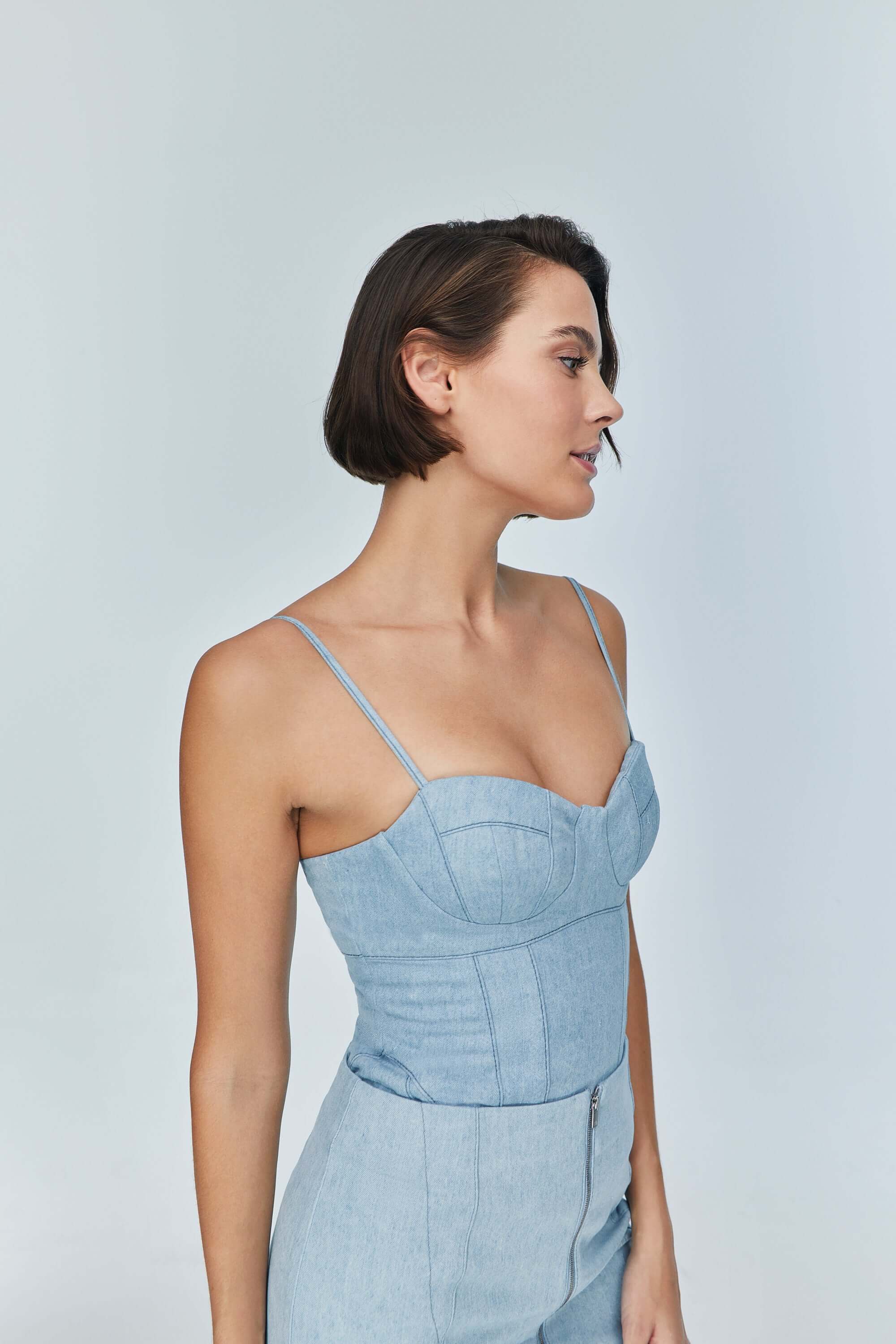 JENDUE fashionable light blue jean bodysuit: V-neckline, form-fitting, with exposed white threads.