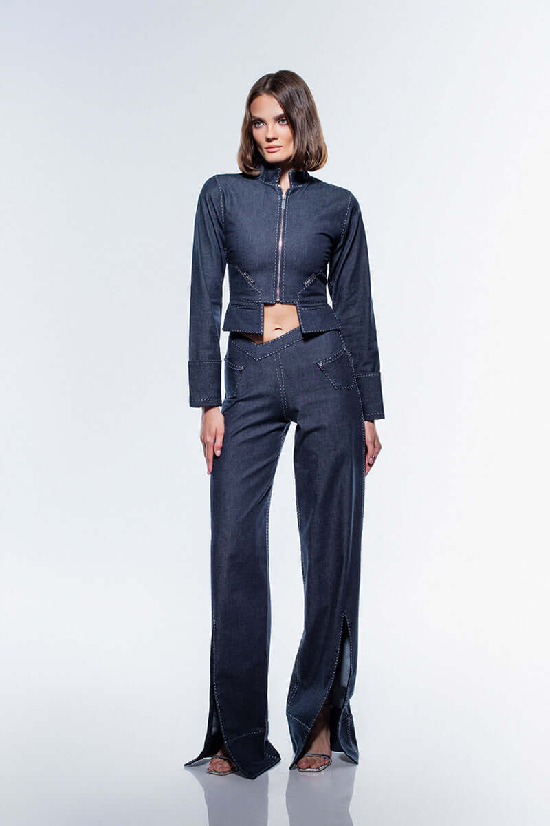 Wide-leg, high-rise jeans in a deep navy color, showcasing a distinctive V-waistband and functional front pockets with studs.