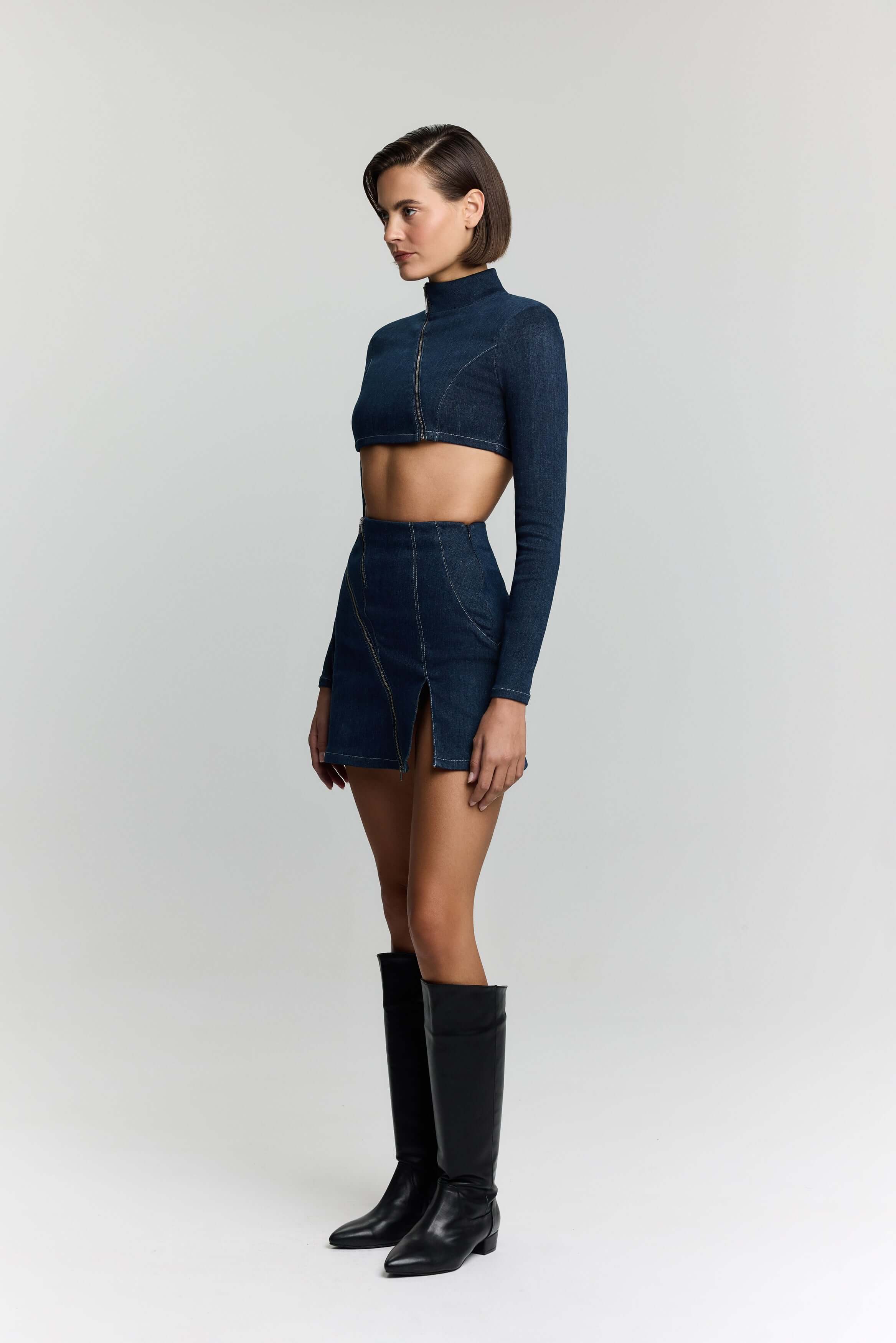 JENDUE's blue denim zip-up top, a cropped design with a high neck and edgy details.
