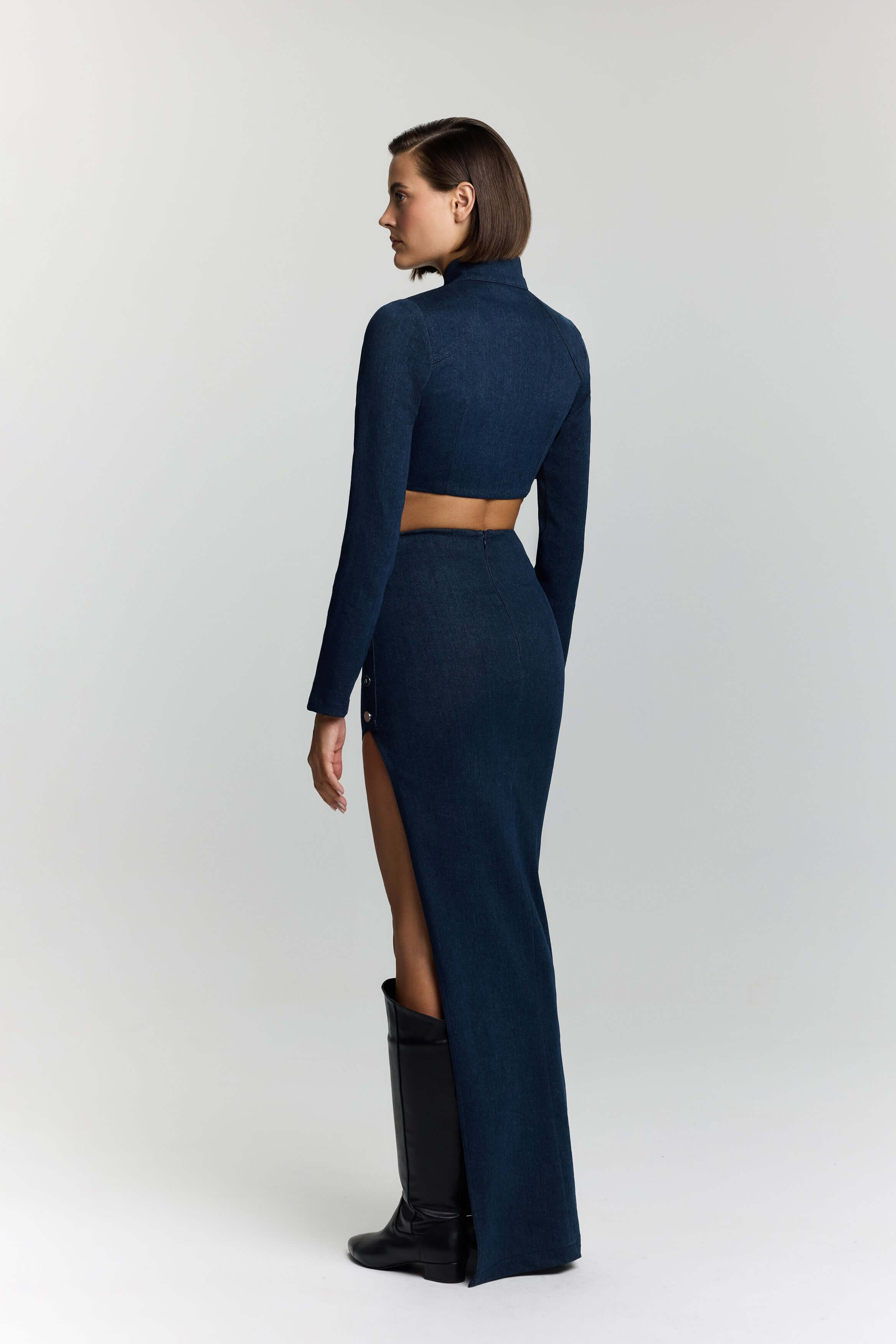 JENDUE Stylish blue denim crop top with a high neckline, long sleeves, and a distinctive chest cutout.