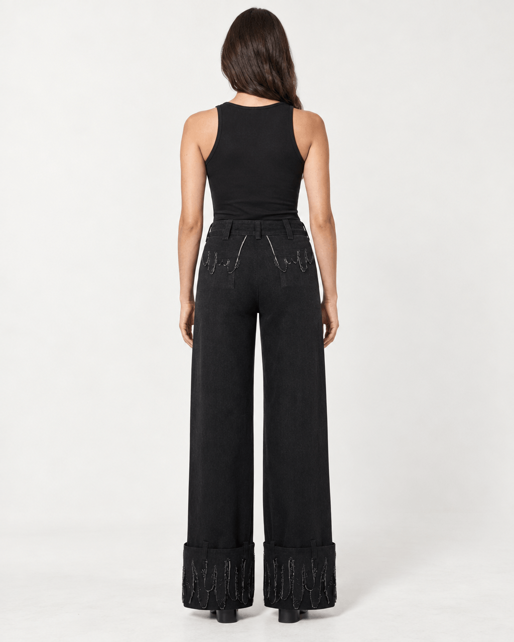 Back view of woman wearing JENDUE Luciano Trousers - Wide-Leg Black Denim Pants with decorative detailing.
