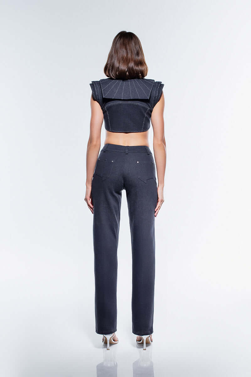 High-neck navy blue denim crop top featuring a front button closure, white contrast stitching, and sculpted shoulders.