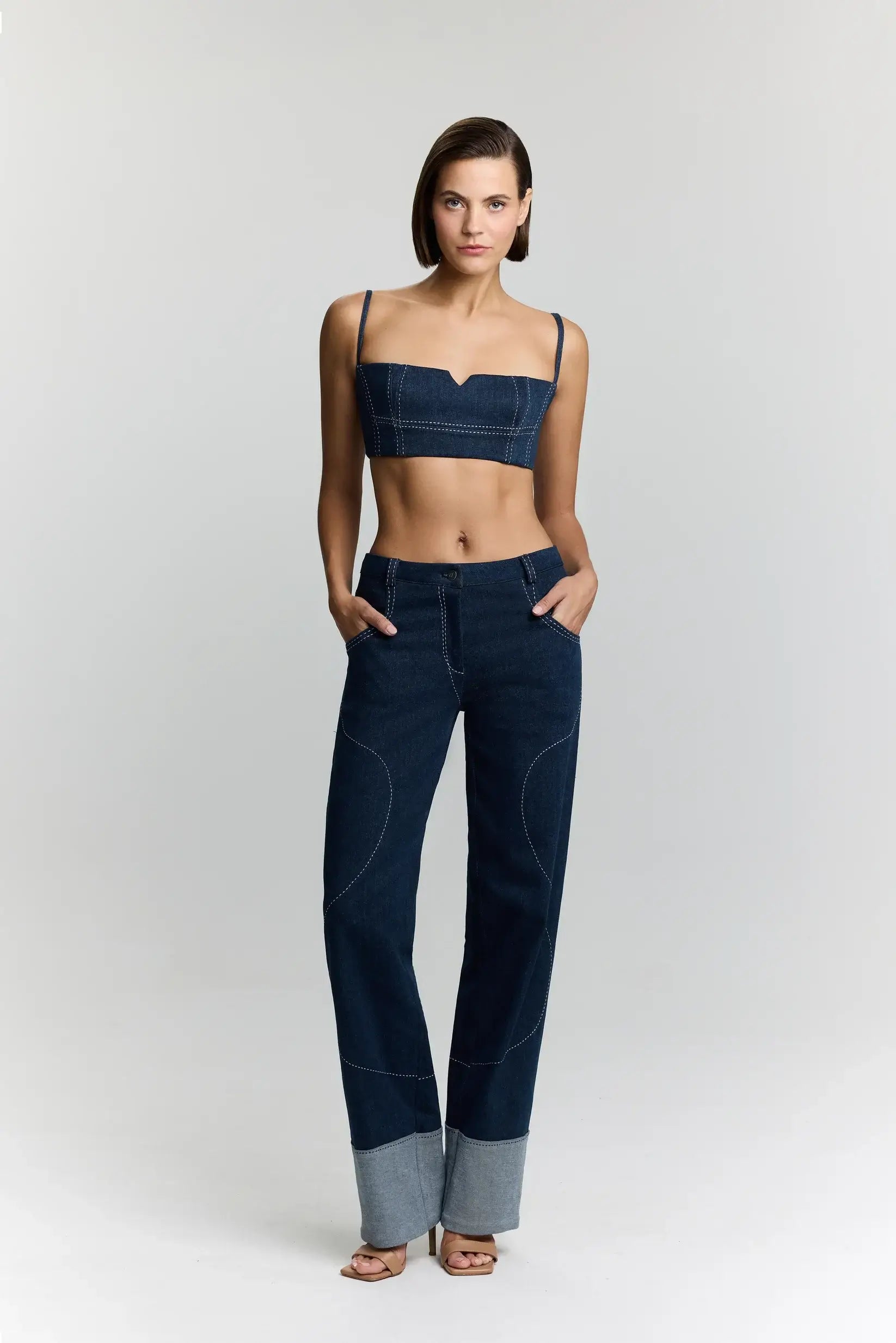 JENDUE blue denim high-waisted wide-leg jeans. Features contrast stitching and cuffed hems.