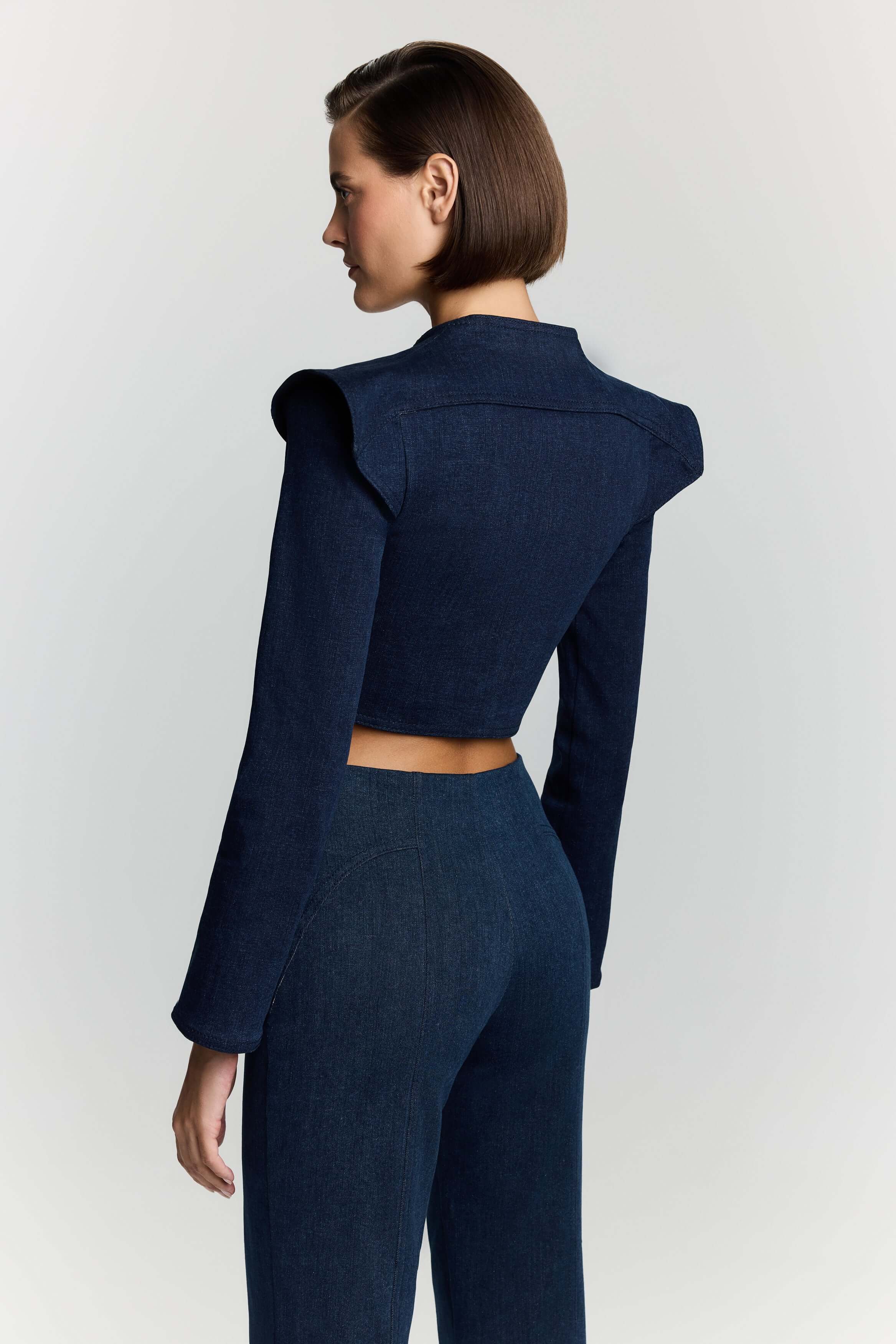 JENDUE's blue denim cropped outerwear, showcasing a fitted silhouette and elegant button details.