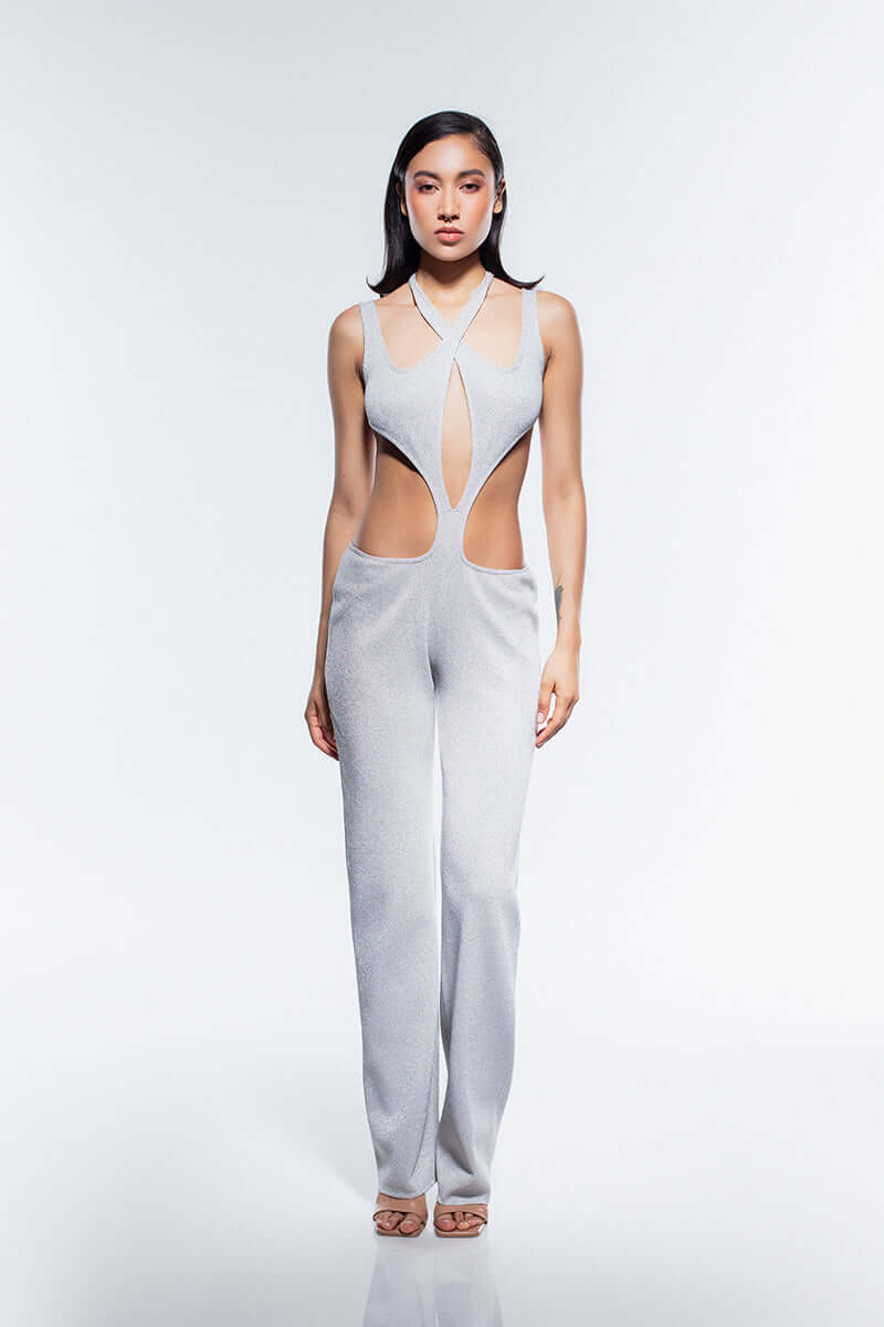Silver, sleeveless jumpsuit with a halter neck and large cutouts on the torso, highlighting the waist.