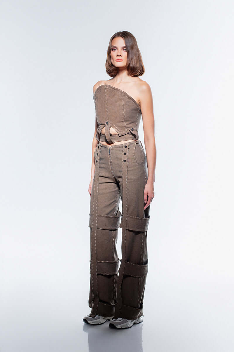 Brown JENDUE denim jeans with a wide-leg cut and bold, strappy design down each leg. High waist with silver buttons.